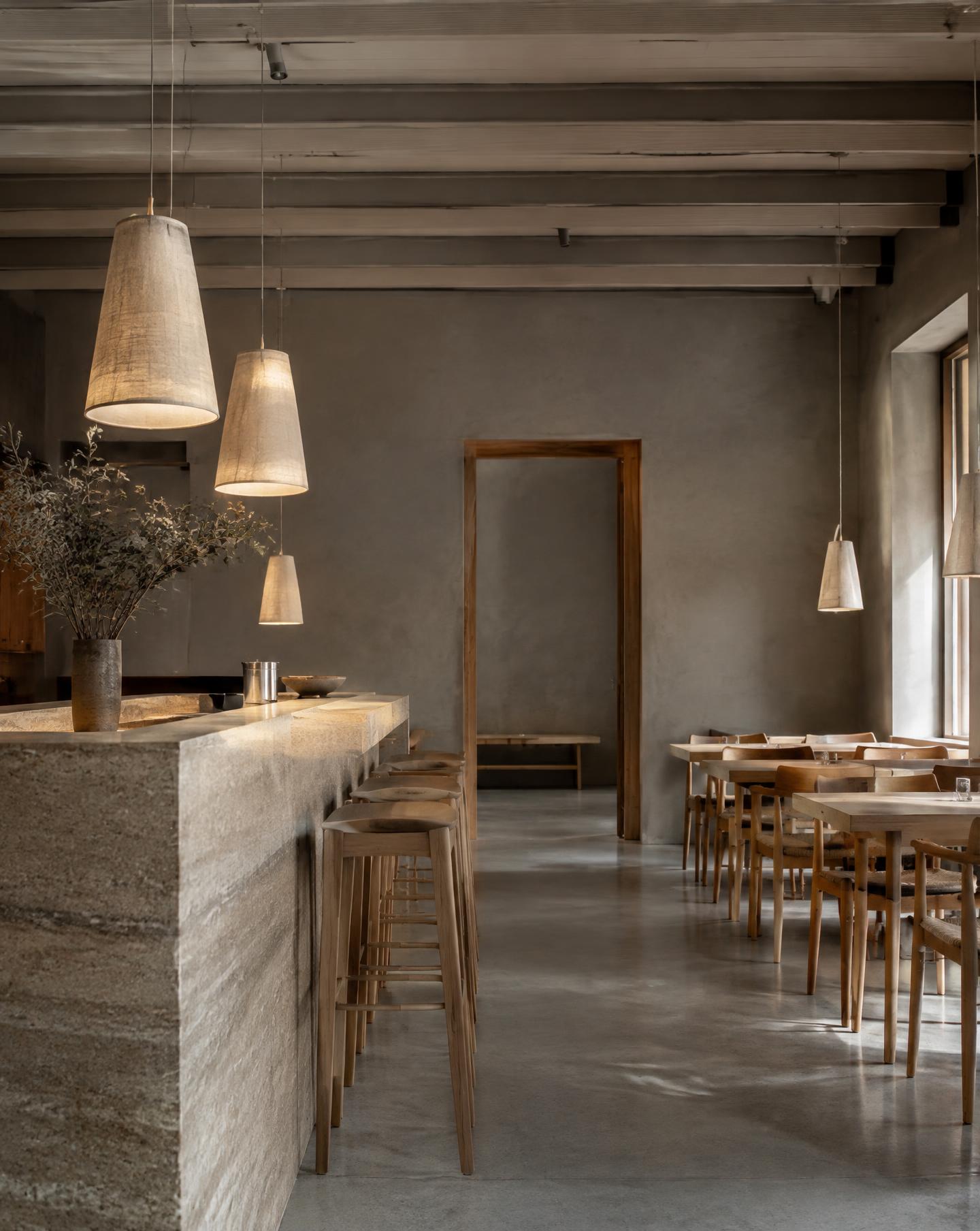 Restaurang med bardisk i travertin och pendlar i linne